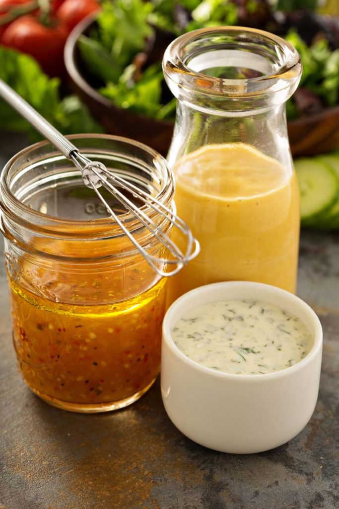 three salad dressings in glass jars