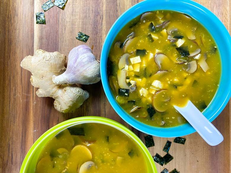 Picture of two bowls of miso soup with garlic and ginger.