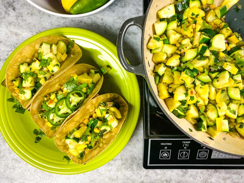 calabacitas in a pan and three calabacitas tacos on a green plate