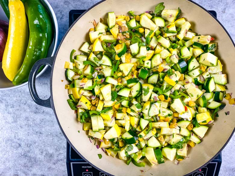 pan of calabacitas on a burner on the counter