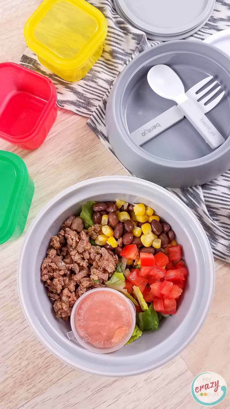 carne asada burrito bowl in meal prep container on wood counter 