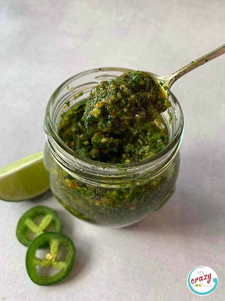 top down image of sauce in glass jar with spoon of sauce being scooped