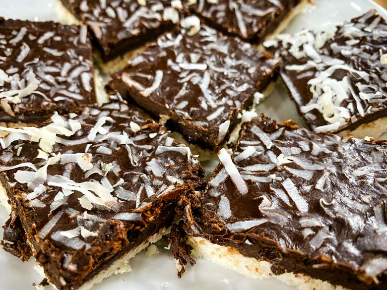 close up of coconut bars on white plate