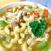 close up of turkey carcass soup in a white bowl