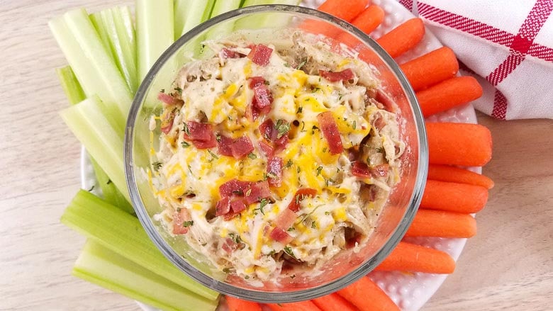 glass bowl with crack dip and carrots and celery around the outside