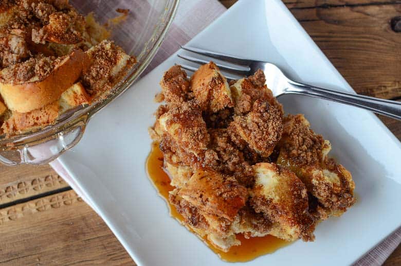 square white plate with dinner roll french toast casserole and fork