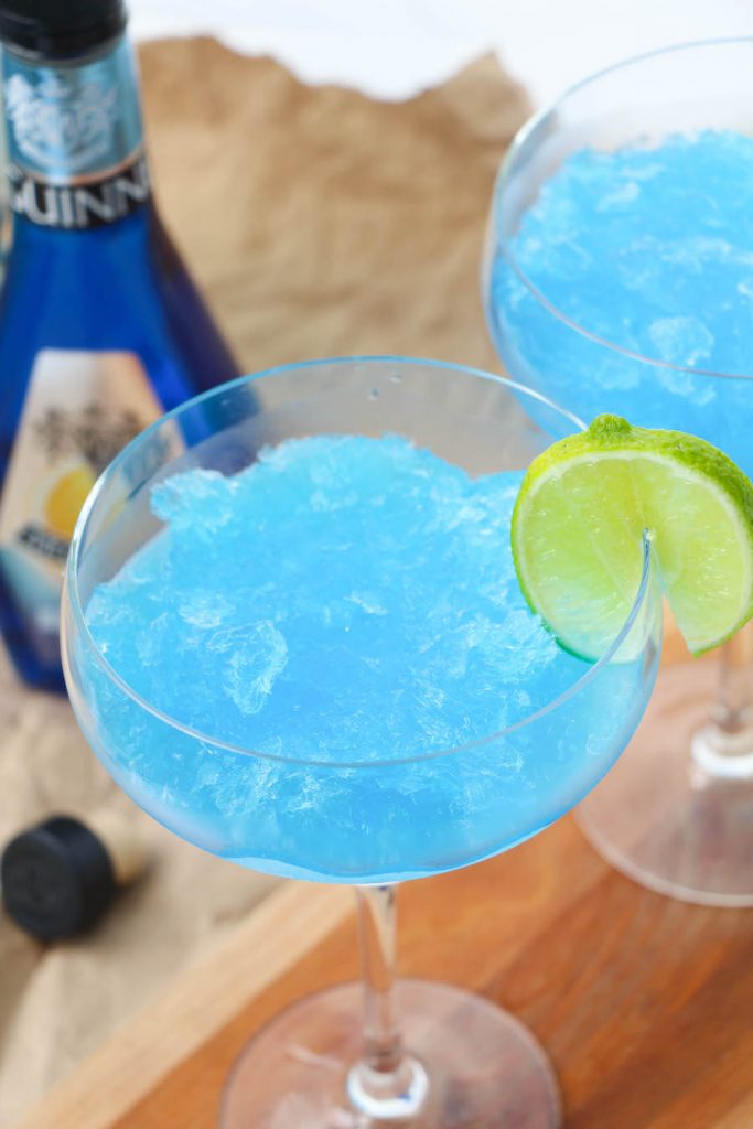 Top down shot of these frozen blue margaritas with a lime slice.