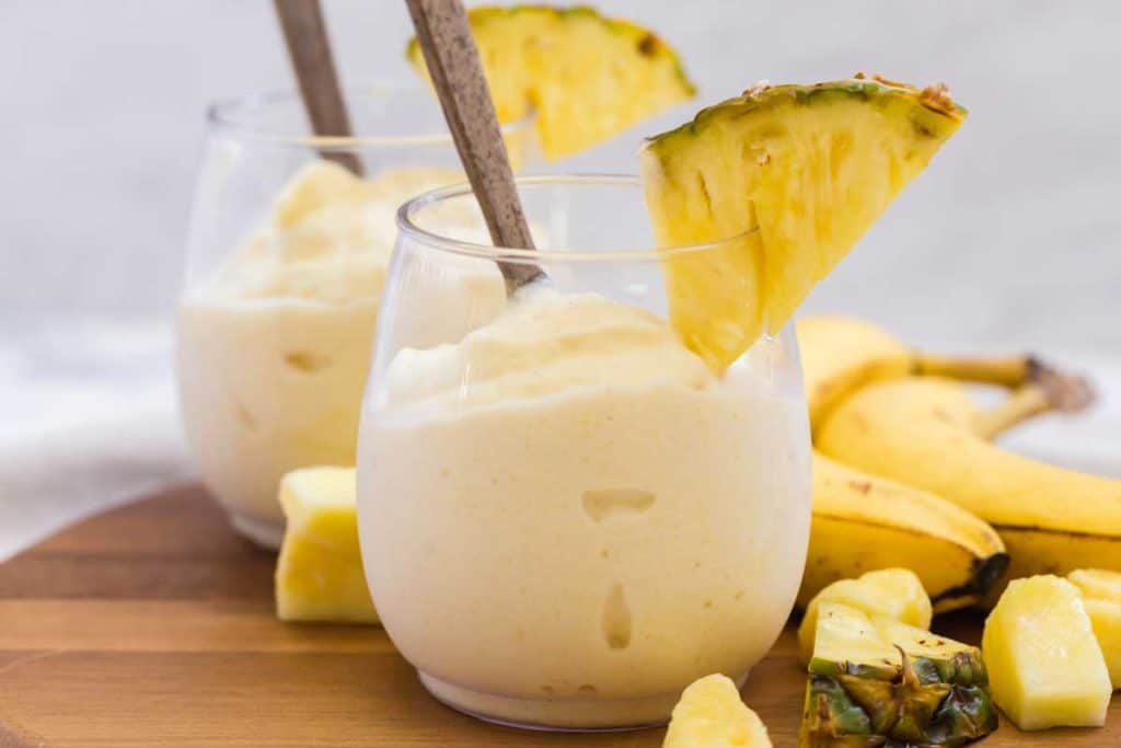 glass full of healthy dole whip and pineapple wedge for garnish