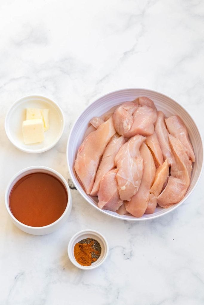 ingredients for WW buffalo Chicken Wings on a white marble counter. Ingredients are in small white bowls. 