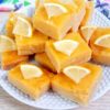 close up of cut lemon bars on a white plate