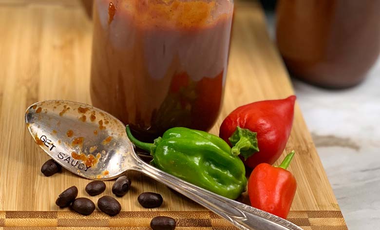 peppers, coffee beans, and bbq sauce on wood cutting board