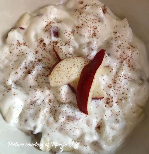 Bowl of Greek yogurt with pears mixed in and sliced pears on top