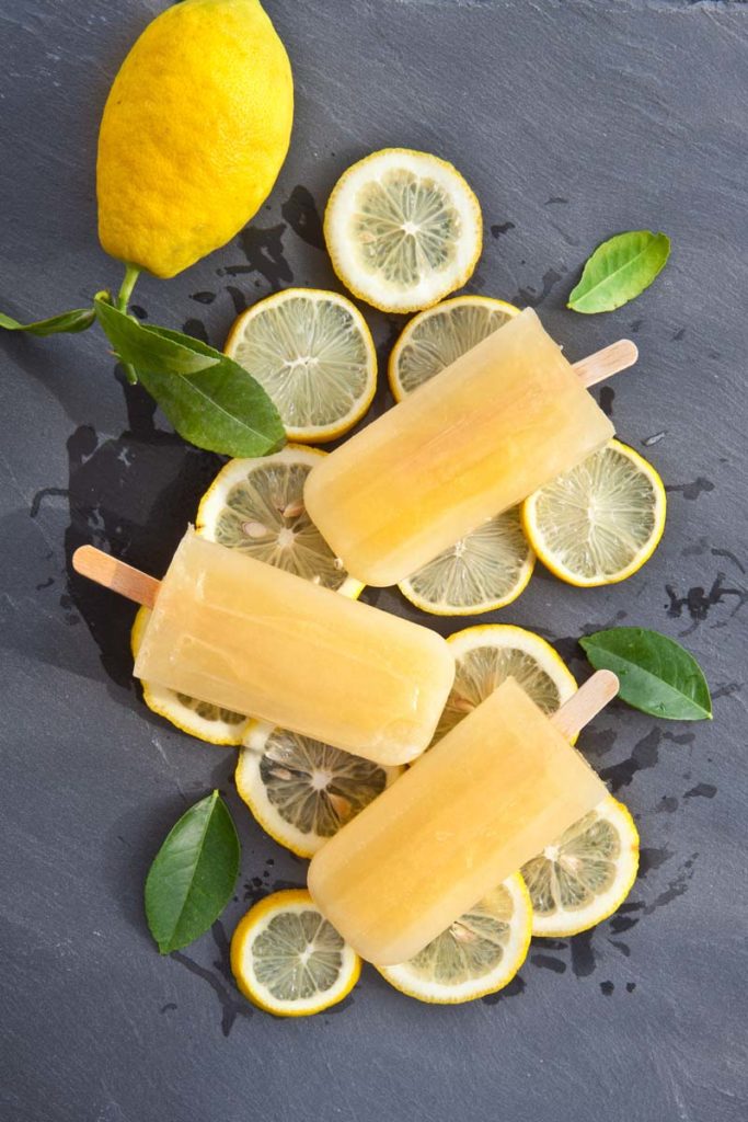 popsicles and lemon slices on a gray slate