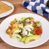 white plate with breakfast fajitas and a plate of toast in the background