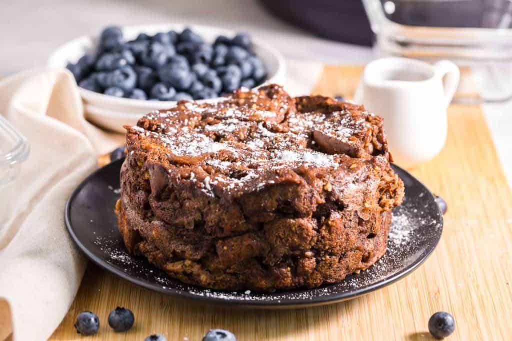 Healthy French Toast Casserole with powdered sugar on top and blueberries in the background