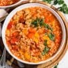 white bowl with stuffed pepper soup on top of a wooded board