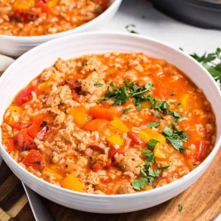 white bowl with stuffed pepper soup on top of a wooded board