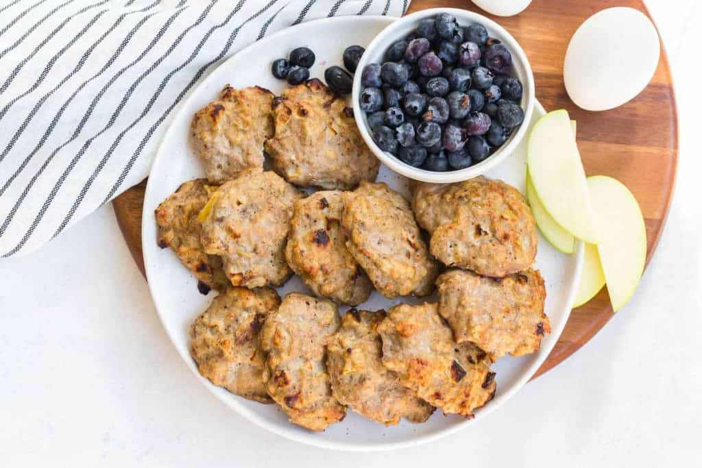 plate with Easy Chicken Apple Sausage Patties and fruit in background