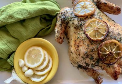 cooked rotisserie chicken on the grill on a white platter