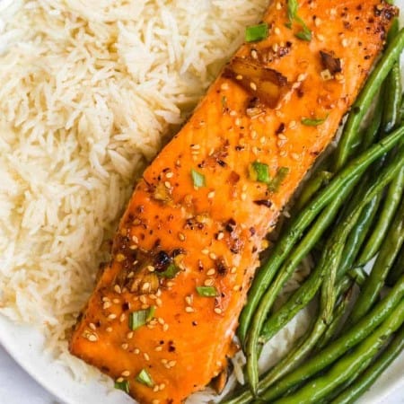 salmon fillet, white rice, and green beans on a white plate