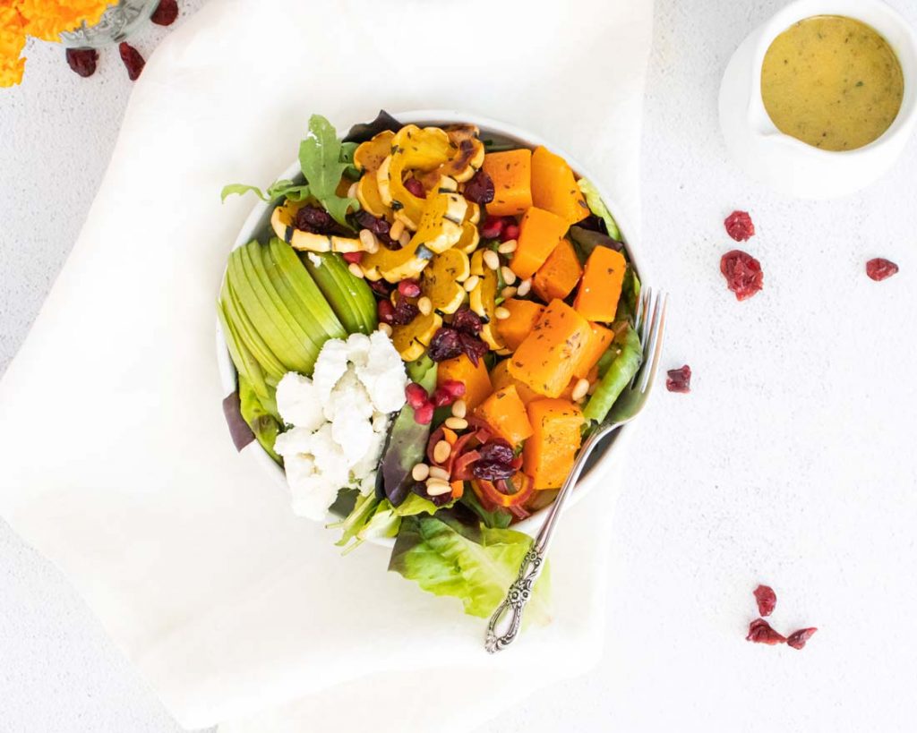 top down view of salad in a white bowl on a white counter