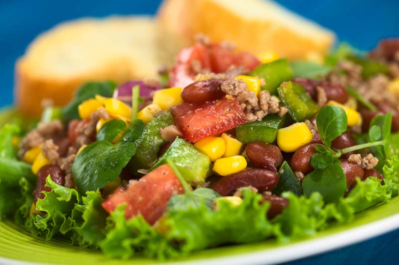 salad with ground beef on a white plate