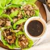 plate of lettuce with ground turkey filling and a bowl of dipping sauce